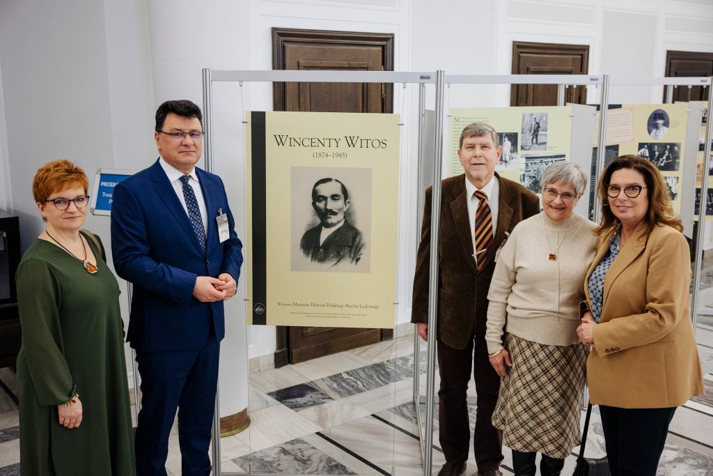 Zdjęcie przedstawia 5 osób obok części wystawy o Wincentym Witosie w Senacie RP.