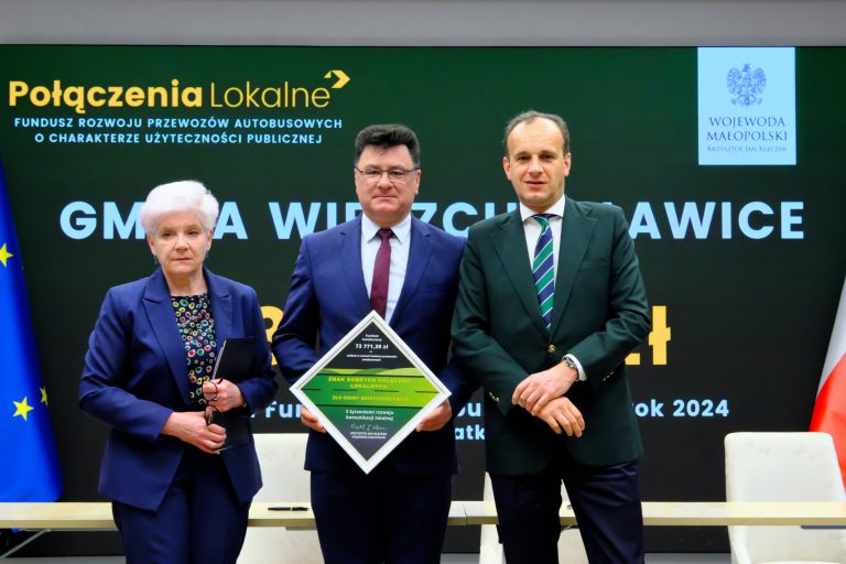 Zdjęcie przedstawia 3 osoby w siedzibie Małopolskiego Urzędu Wojewódzkiego w Krakowie podczas uroczystego podpisania umów w ramach Funduszu rozwoju przewozów autobusowych użyteczności publicznej
