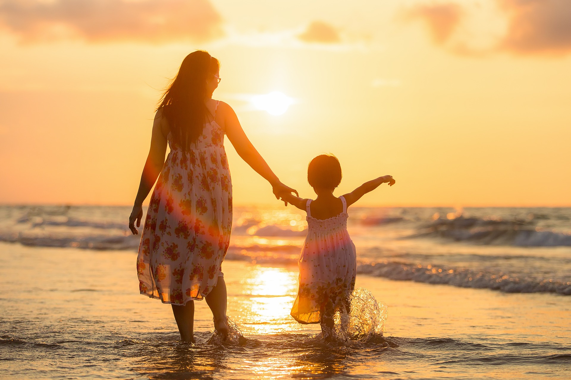 Kobieta spaceruje na plaż córką za rękę